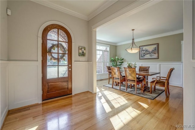 foyer with light hardwood / wood-style floors and crown molding