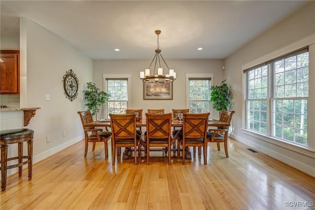 dining area with a chandelier and light hardwood / wood-style floors