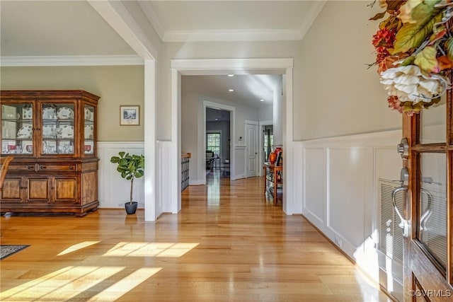 hall with light hardwood / wood-style flooring and crown molding