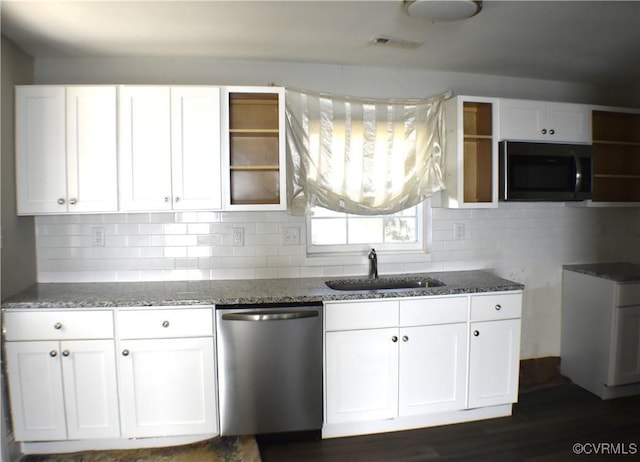 kitchen featuring decorative backsplash, dark stone counters, sink, dishwasher, and white cabinetry