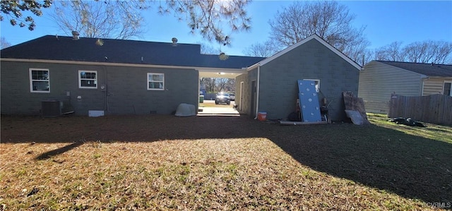 rear view of property with a lawn and cooling unit