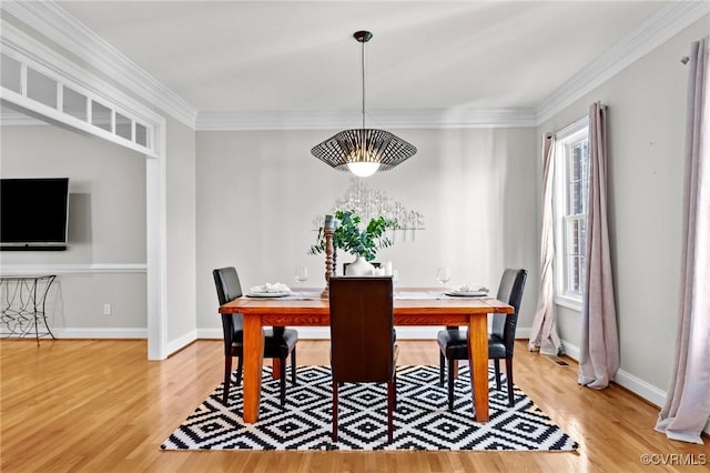 dining space with a wealth of natural light, crown molding, and hardwood / wood-style floors