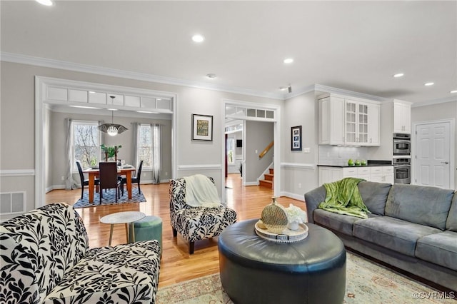 living room with light hardwood / wood-style floors and ornamental molding