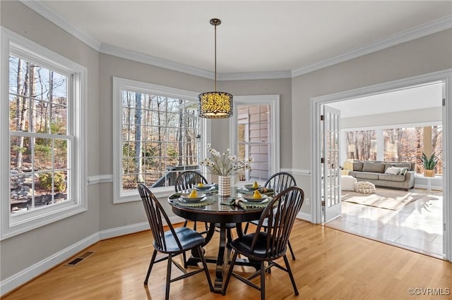 dining room featuring crown molding and light hardwood / wood-style flooring