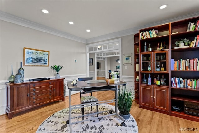 office with light hardwood / wood-style flooring and ornamental molding