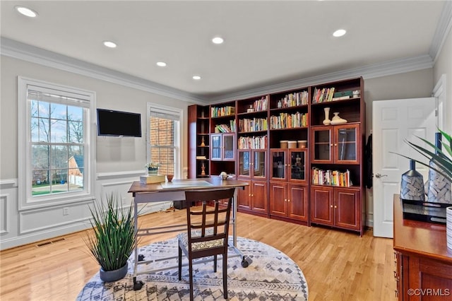 office with light hardwood / wood-style floors and crown molding