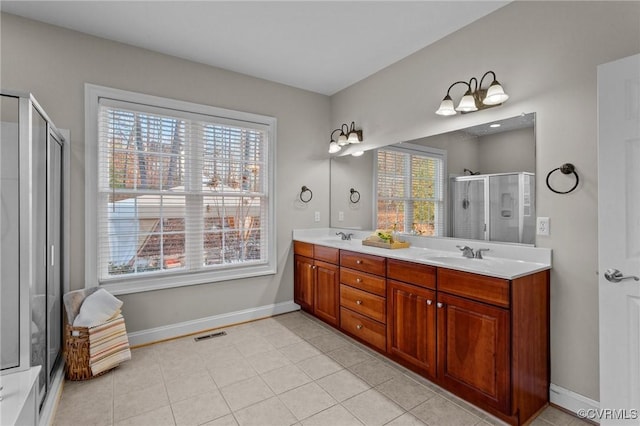 bathroom featuring a wealth of natural light, a shower with door, vanity, and tile patterned flooring