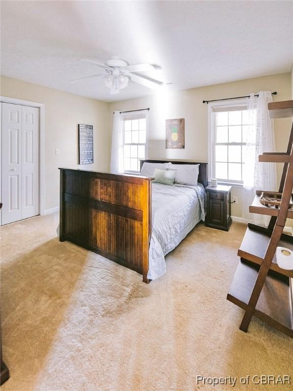 carpeted bedroom with a closet and ceiling fan