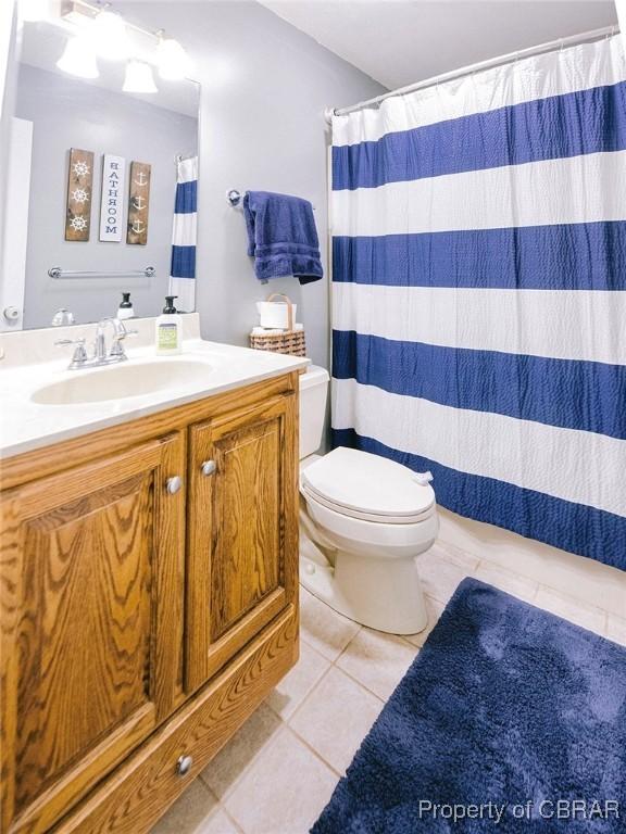 bathroom with tile patterned flooring, vanity, and toilet