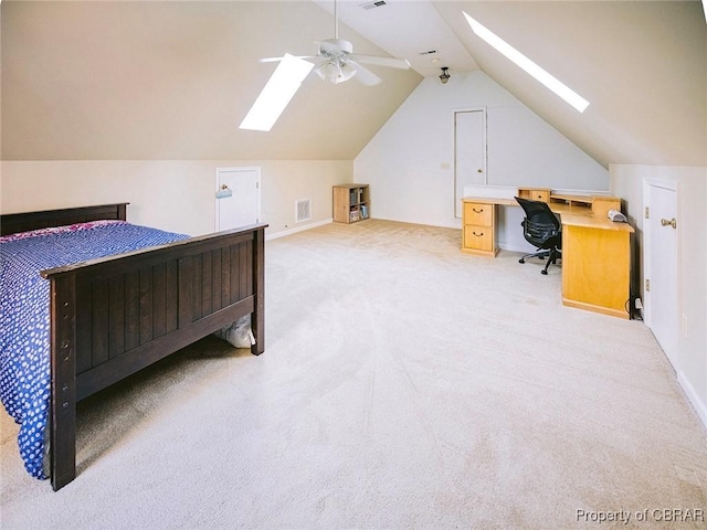 bedroom with light colored carpet, ceiling fan, and vaulted ceiling with skylight