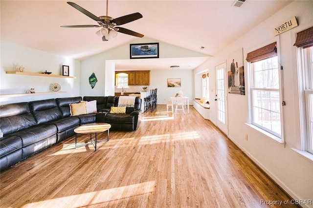 living room with a healthy amount of sunlight, ceiling fan, light hardwood / wood-style floors, and lofted ceiling