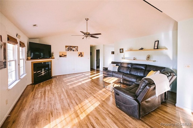 living room with hardwood / wood-style flooring, vaulted ceiling, and ceiling fan