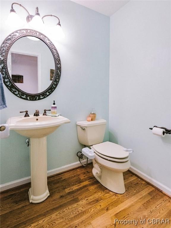 bathroom with hardwood / wood-style floors and toilet