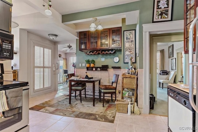 interior space featuring dishwasher, stove, ceiling fan with notable chandelier, and light tile patterned floors