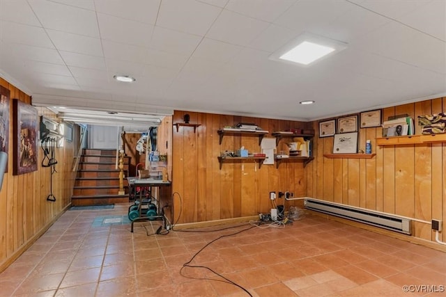 exercise room featuring wooden walls and a baseboard radiator