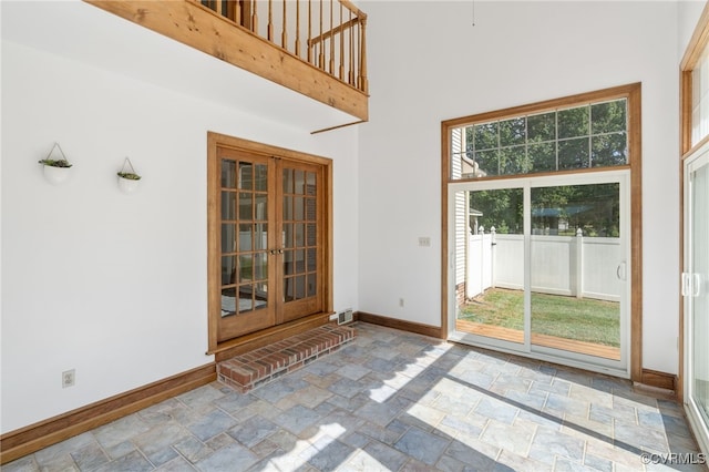 doorway to outside with french doors and a high ceiling