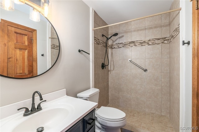 bathroom featuring vanity, toilet, and tiled shower