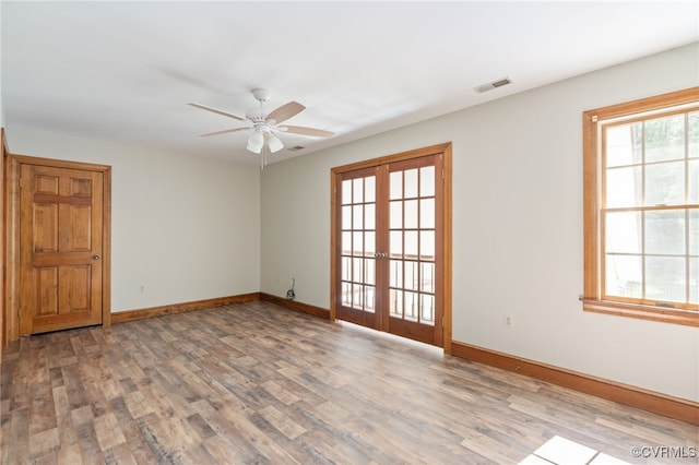 empty room with hardwood / wood-style floors, ceiling fan, and french doors