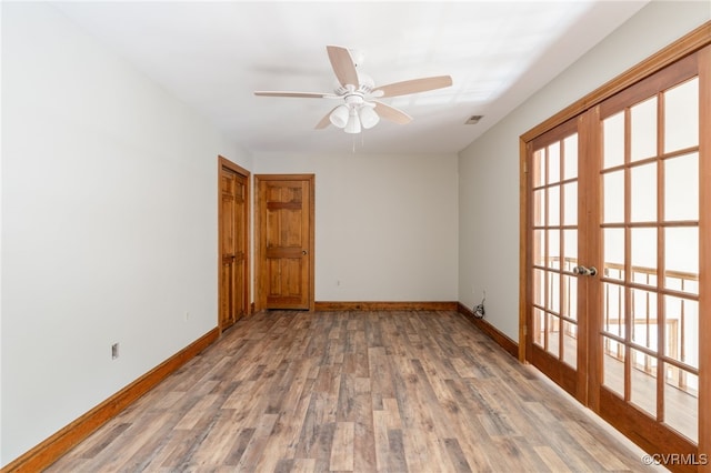 empty room featuring hardwood / wood-style floors, ceiling fan, and french doors