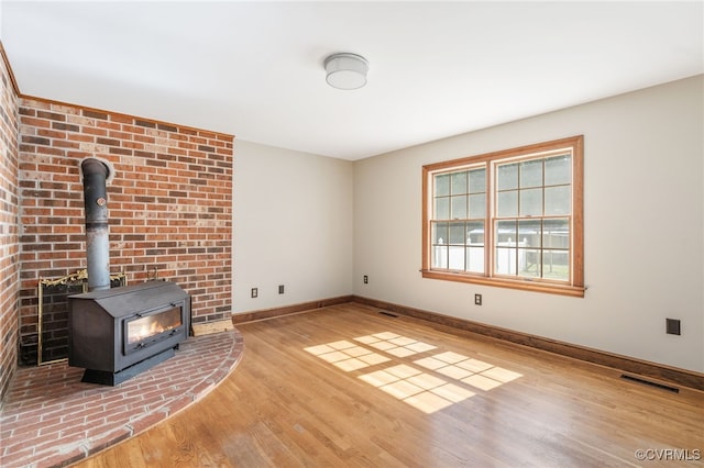 unfurnished living room featuring light hardwood / wood-style flooring and a wood stove