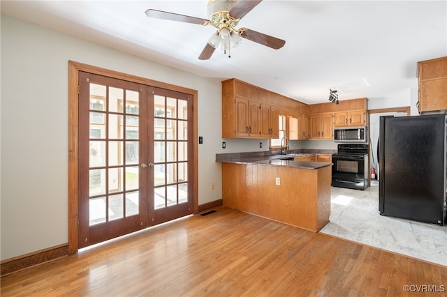 kitchen featuring sink, french doors, light hardwood / wood-style flooring, kitchen peninsula, and black appliances