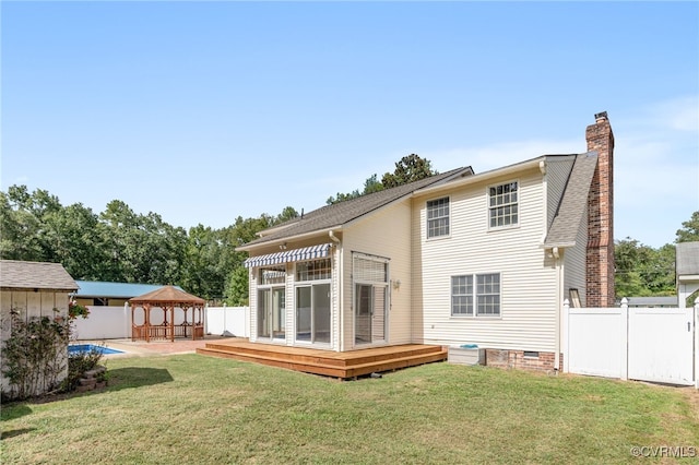 rear view of house with a gazebo, a deck, and a yard