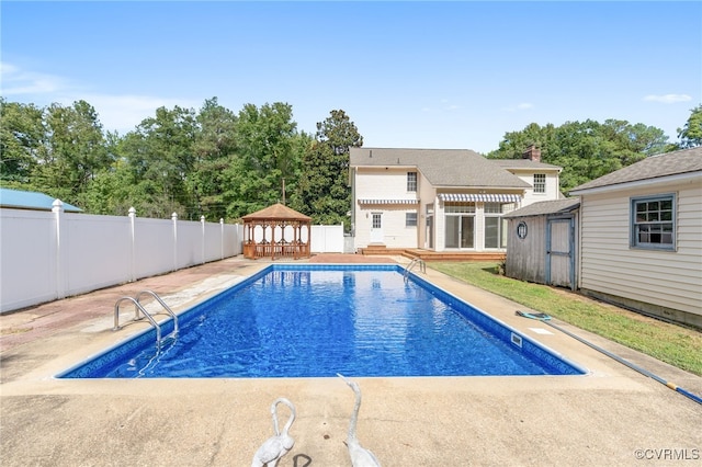 view of pool with a gazebo, a deck, and a storage unit