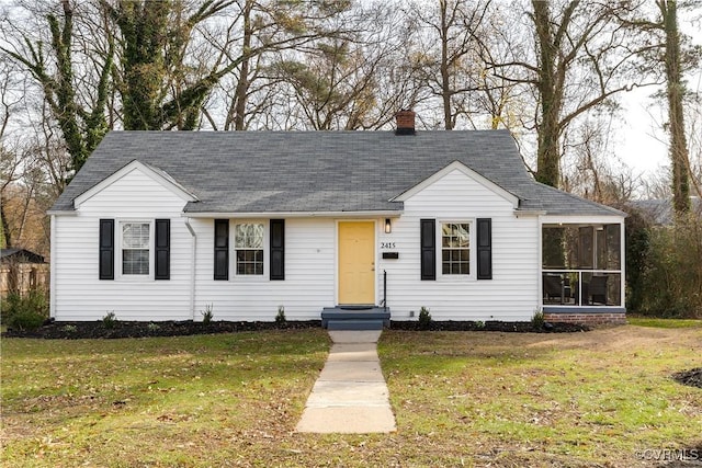 view of front of house with a sunroom and a front yard