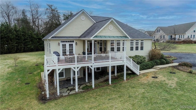 rear view of house with french doors and a lawn