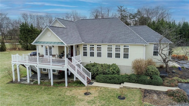 rear view of house featuring a lawn and a deck