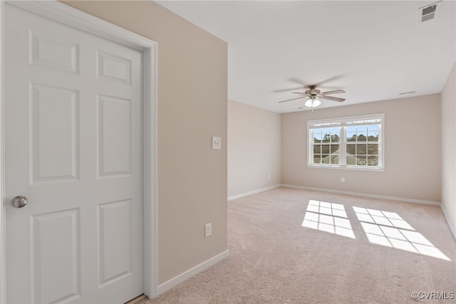 spare room featuring ceiling fan and light colored carpet