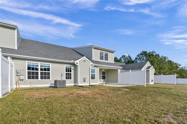 rear view of property featuring central air condition unit, a patio, and a yard