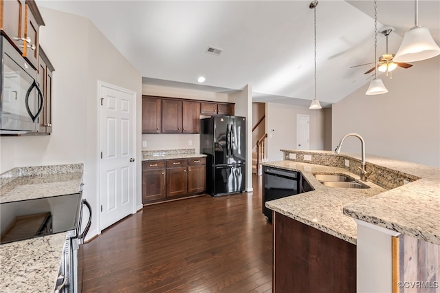 kitchen featuring lofted ceiling, pendant lighting, black appliances, sink, and light stone counters