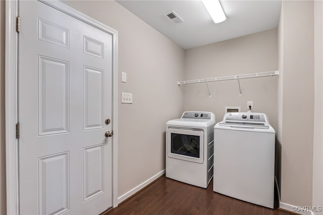 clothes washing area with washing machine and dryer and dark wood-type flooring