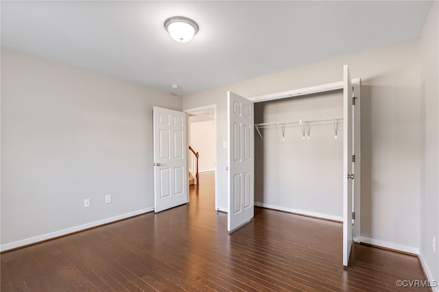 unfurnished bedroom featuring a closet and dark hardwood / wood-style flooring