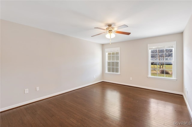 unfurnished room featuring ceiling fan, dark wood-type flooring, and a healthy amount of sunlight