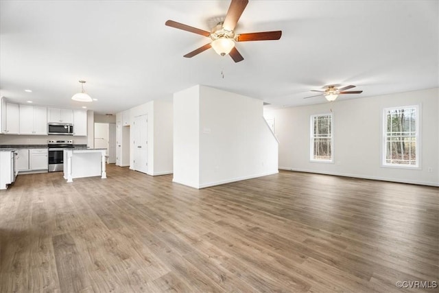 unfurnished living room with ceiling fan and hardwood / wood-style flooring