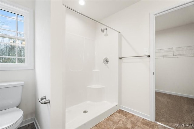 bathroom featuring a shower and toilet