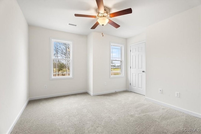 spare room with ceiling fan and light carpet