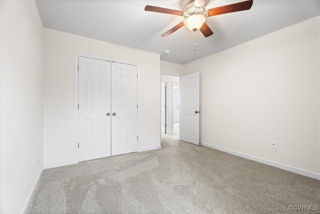 unfurnished bedroom with ceiling fan, a closet, and light carpet