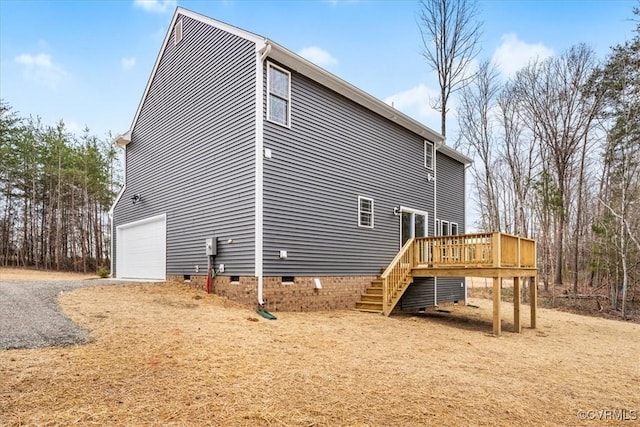 back of house featuring a wooden deck and a garage