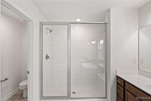 bathroom with vanity, toilet, and a shower with door