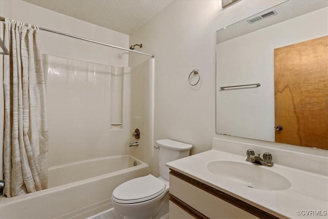 full bathroom featuring shower / bath combo with shower curtain, vanity, a textured ceiling, and toilet