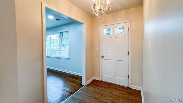 foyer entrance featuring dark wood-type flooring and a chandelier