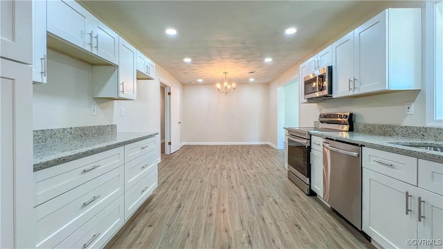 kitchen featuring light stone countertops, white cabinetry, and stainless steel appliances