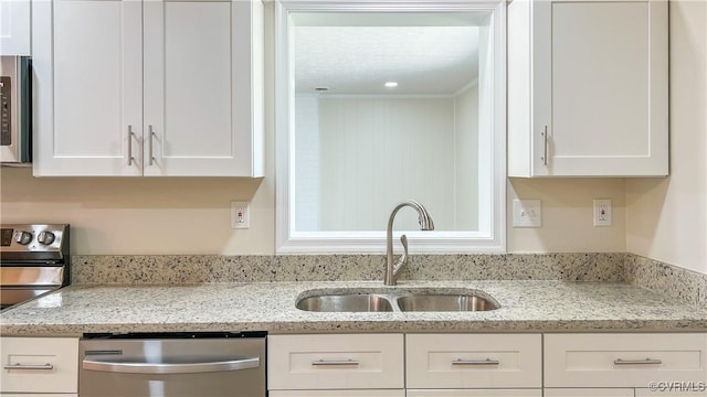 kitchen with light stone countertops, white cabinetry, sink, and appliances with stainless steel finishes