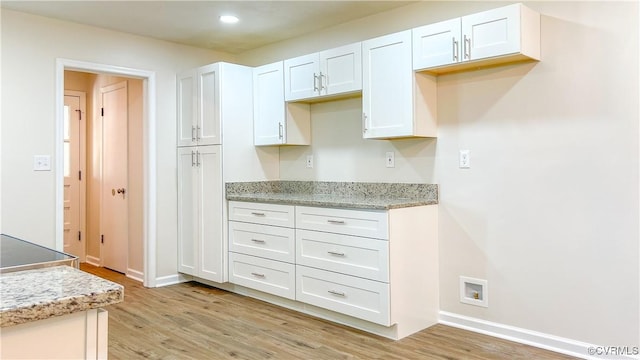 kitchen featuring light wood-type flooring and white cabinetry