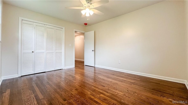 unfurnished bedroom with ceiling fan, dark wood-type flooring, and a closet