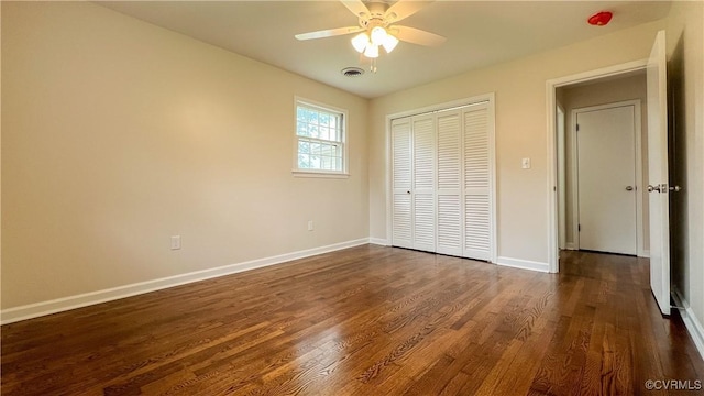 unfurnished bedroom featuring ceiling fan, dark hardwood / wood-style flooring, and a closet