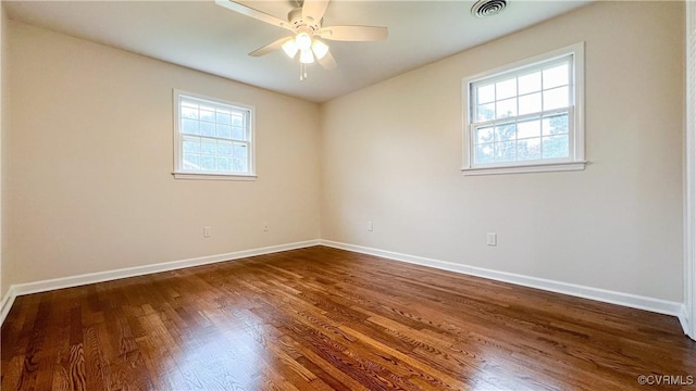 empty room with dark hardwood / wood-style floors, plenty of natural light, and ceiling fan